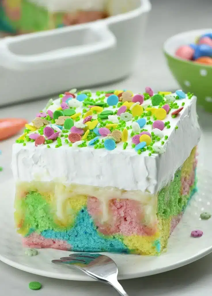 Colorful Easter Poke Cake topped with frosting and Easter-themed decorations.