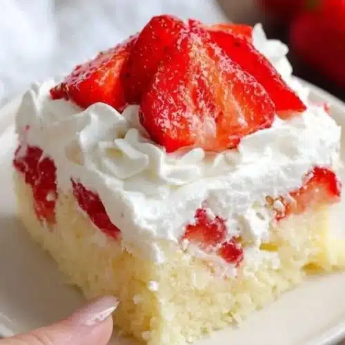 Easy Jello Poke Cake topped with whipped cream and fresh fruit